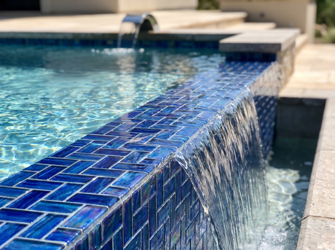 Tiled infinity-edge pool with integrated lighting and clear, balanced water